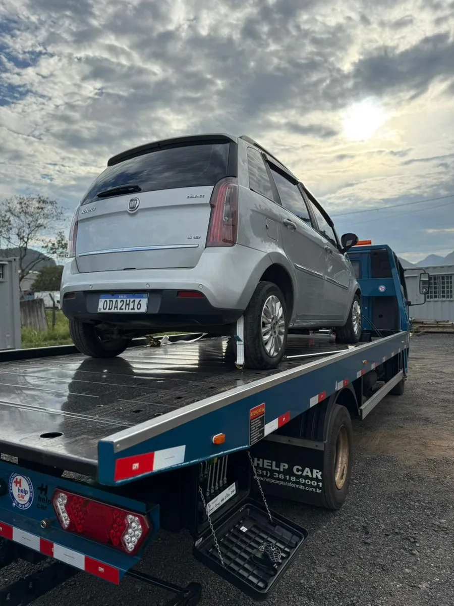Fiat Idea prata fixado com cintas na plataforma do guincho